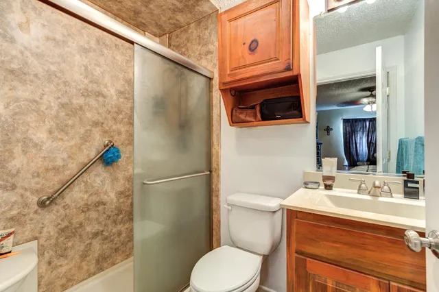 a bathroom with a sink a toilet and shower