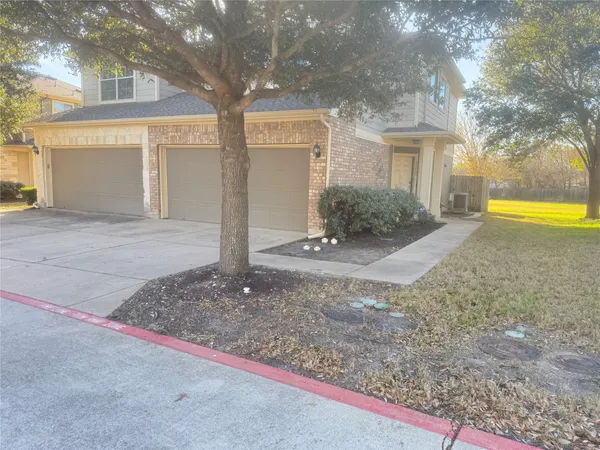 a view of a house with backyard and tree