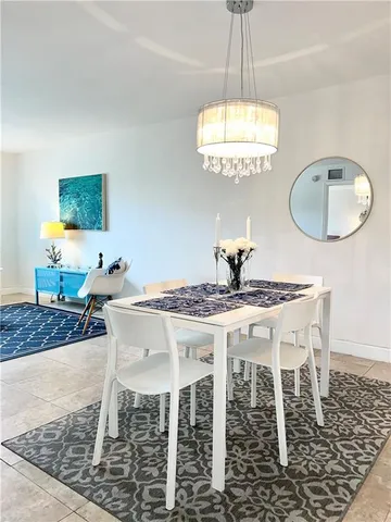a dining room with furniture a rug and a chandelier