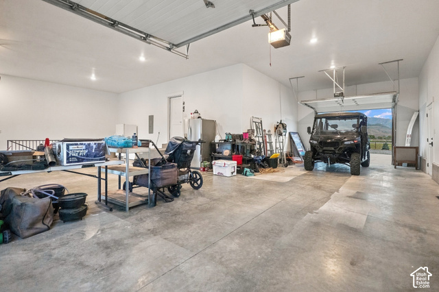244 East Sevier River Road Central Valley, UT 84754 - Photo 66 of 66 Spacious garage with concrete flooring, multiple overhead garage doors, and overhead lighting fixtures