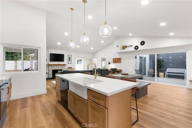 a large kitchen with kitchen island a stove a sink a refrigerator and a living room view