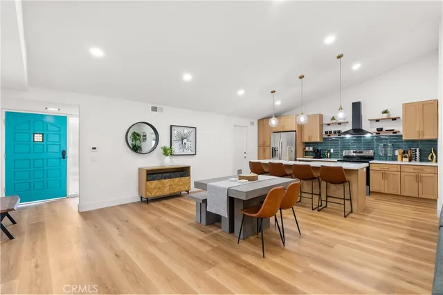 a living room with stainless steel appliances kitchen island granite countertop furniture and a wooden floor