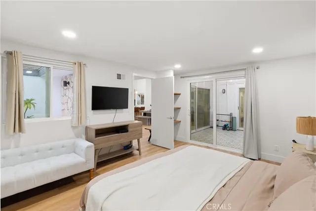 a bedroom with a bed and a flat screen tv