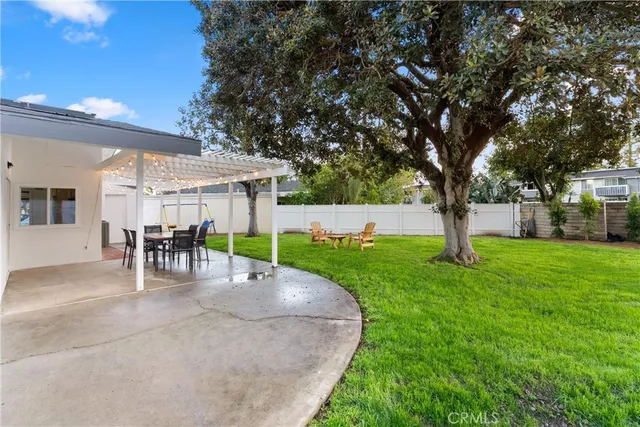 a view of a house with backyard and a tree