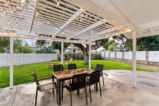 a view of a patio with a table chairs and a backyard
