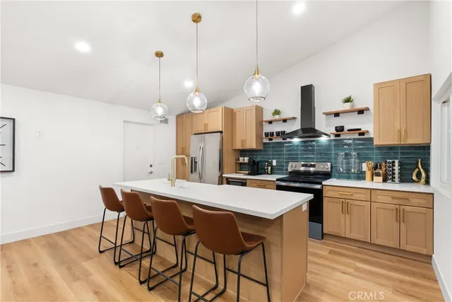 a kitchen with stainless steel appliances a stove a sink a island with a dining table and chairs