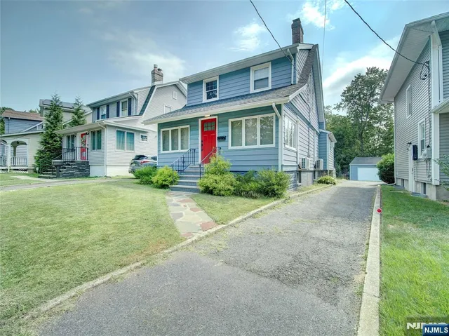 a front view of a house with a yard and trees