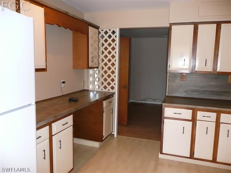 5952 Sailfish Road Bokeelia, FL 33922 - Photo 12 of 20 a kitchen with granite countertop cabinets and window