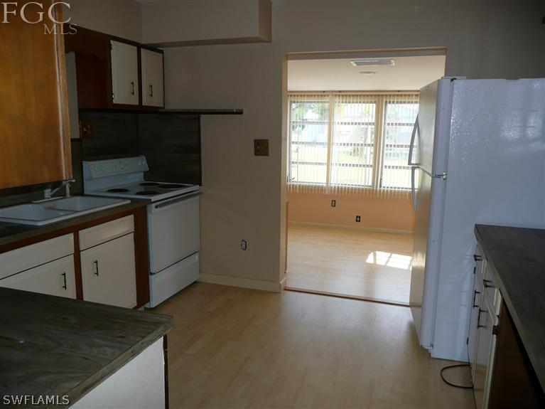 5952 Sailfish Road Bokeelia, FL 33922 - Photo 13 of 20 a kitchen with granite countertop a stove a sink and a refrigerator