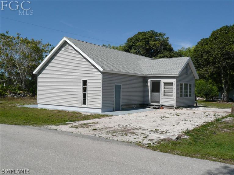 5952 Sailfish Road Bokeelia, FL 33922 - Photo 3 of 20 a front view of a house with a yard and garage