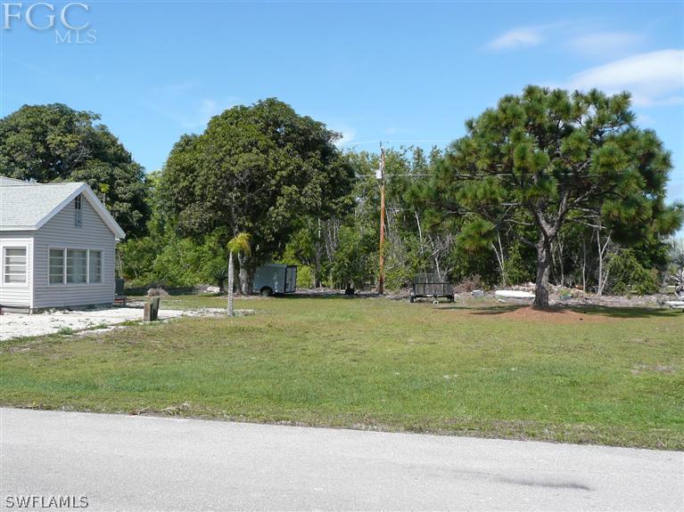5952 Sailfish Road Bokeelia, FL 33922 - Photo 7 of 20 a view of a house with a big yard and palm trees