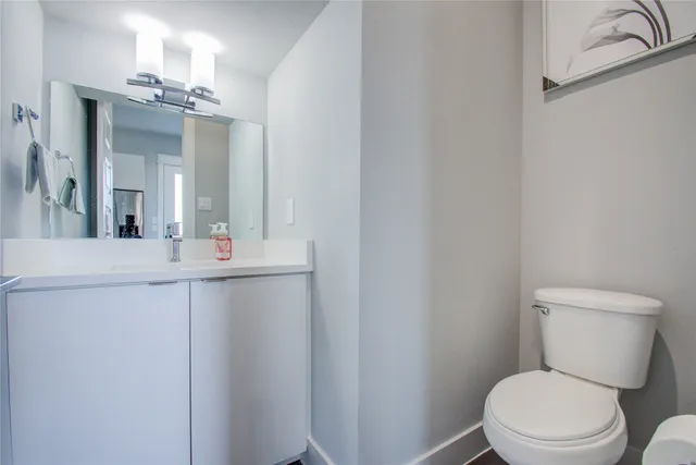 a bathroom with a toilet a sink and mirror