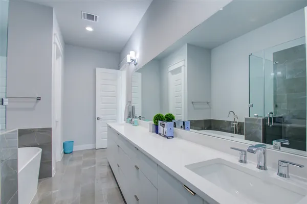 a bathroom with a double vanity sink mirror and bathtub