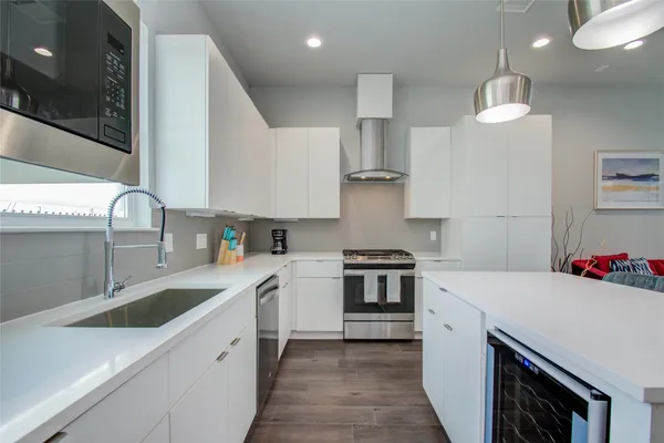 a kitchen with stainless steel appliances a sink stove and cabinets