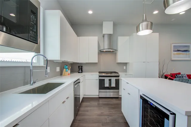 a kitchen with stainless steel appliances a sink stove and cabinets