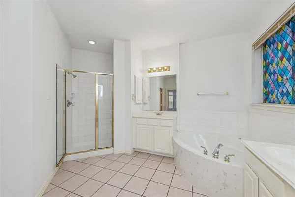 a bathroom with a bathtub sink vanity and mirror