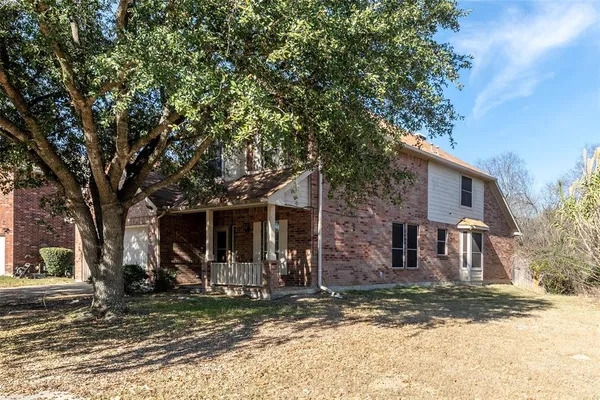 a view of a house with a tree in front