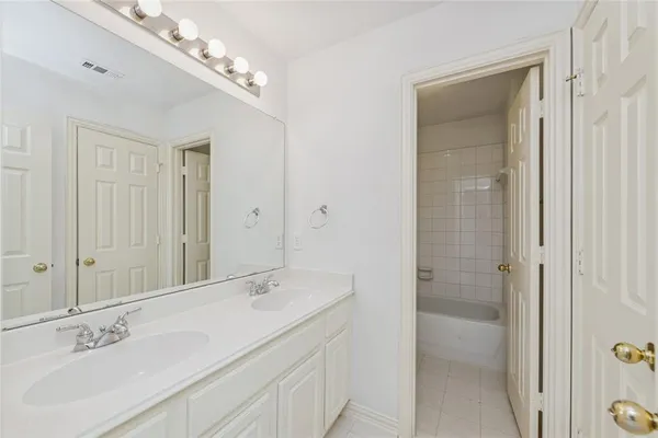 a spacious bathroom with a shower sink and mirror