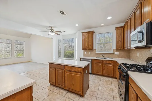 a kitchen with stainless steel appliances granite countertop a sink and cabinets