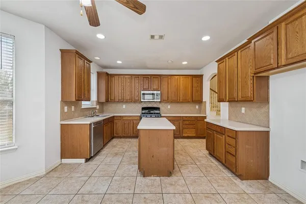 a large kitchen with stainless steel appliances lots of counter top space