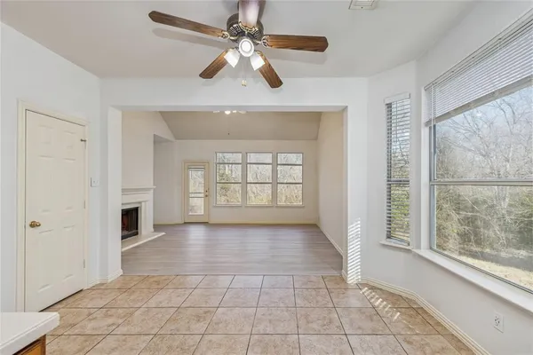 a view of an empty room with a window and a kitchen