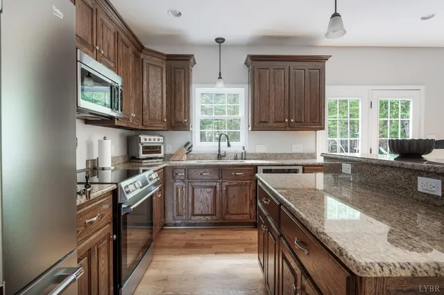 a kitchen with granite countertop a refrigerator stove top oven and sink