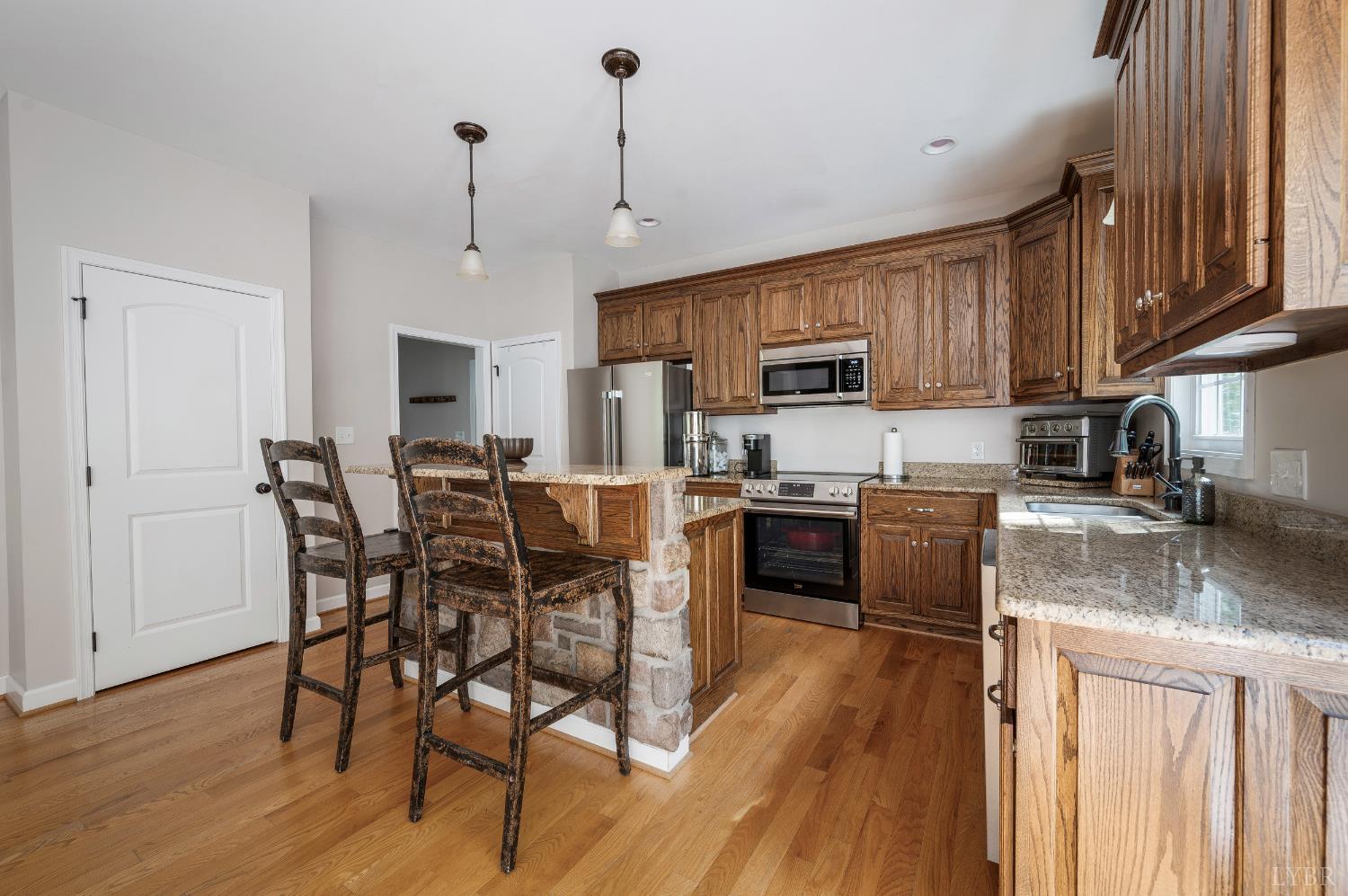 333 Sunset Ridge Drive Concord, VA 24538 - Photo 23 of 61 a kitchen with stainless steel appliances granite countertop a stove top oven a sink dishwasher a dining table and chairs with wooden floor