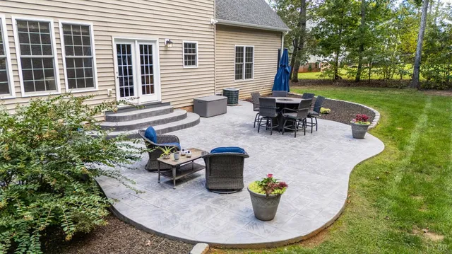 a view of a patio with table and chairs and a garden