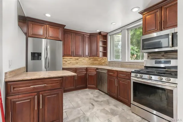 a kitchen with stainless steel appliances granite countertop a stove microwave and refrigerator