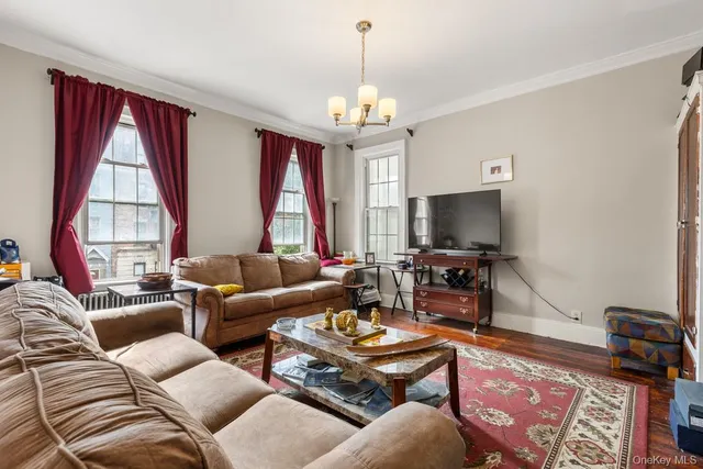 a living room with furniture a large window and a flat screen tv