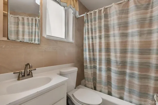 a bathroom with a sink a toilet and shower curtain