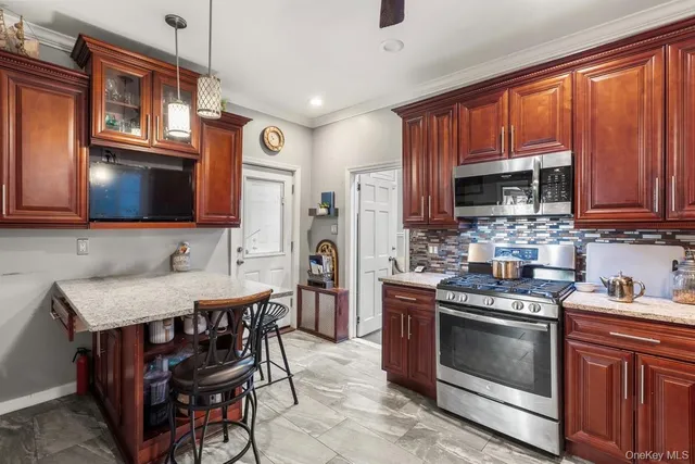 a kitchen with stainless steel appliances a stove microwave and a sink