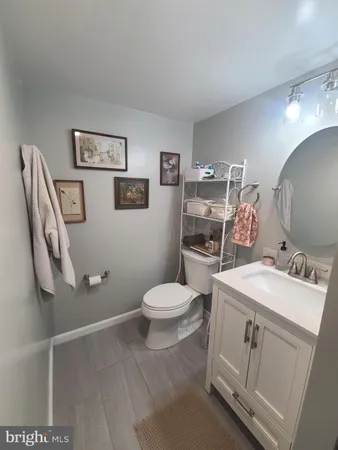 a bathroom with a toilet sink vanity and mirror