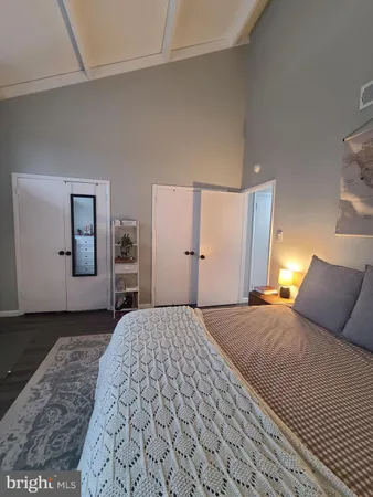 a bedroom with a large bed and wooden floor