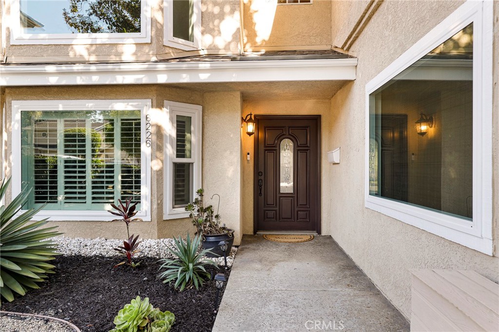 a view of a door of the house with potted plants