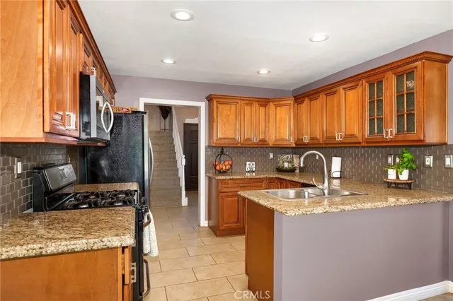 a kitchen with stainless steel appliances granite countertop a sink stove and refrigerator