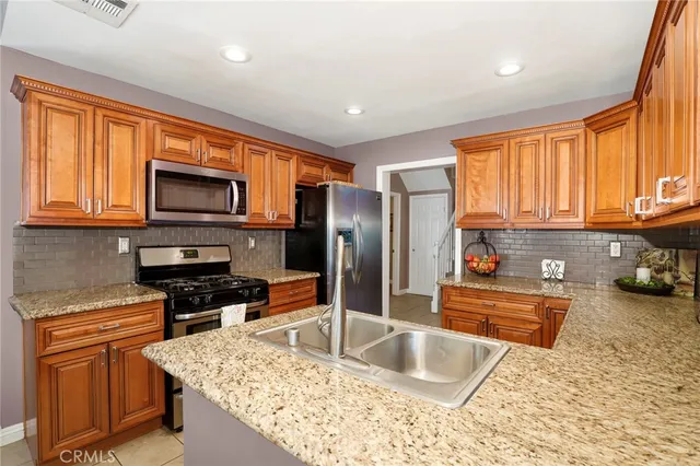 a kitchen with stainless steel appliances granite countertop a sink stove and refrigerator