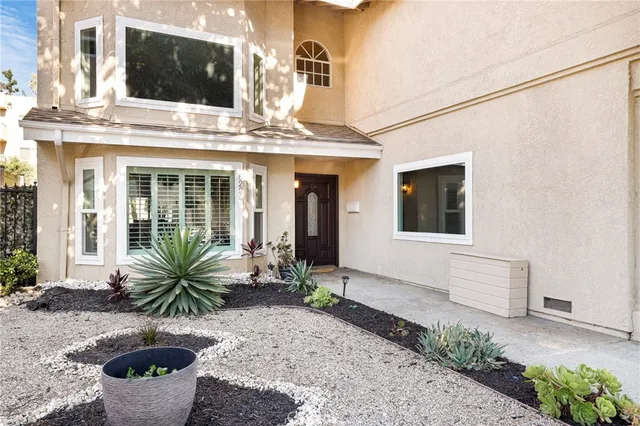 a view of a house with potted plants and more windows