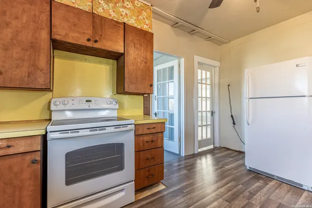 a kitchen with a stove cabinets and wooden floor