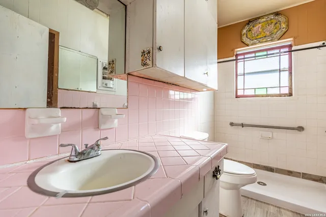 a bathroom with a sink a toilet and a mirror