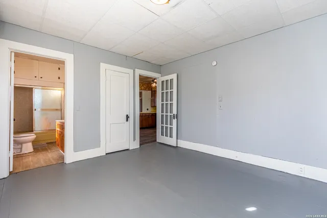 an empty room with fan and a bathroom