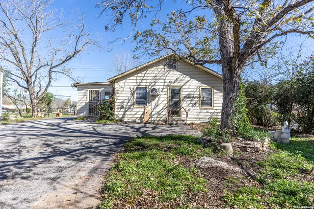 a view of a house with a yard and pathway