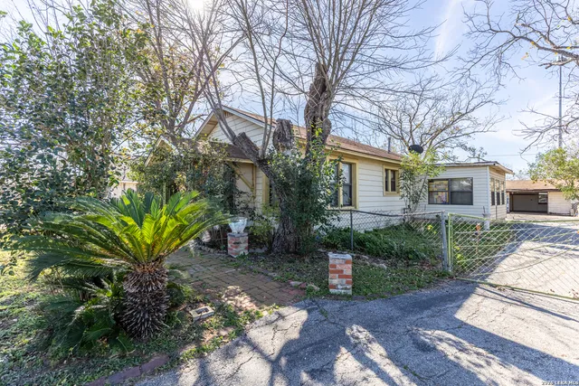 a view of a garden with a house in the background