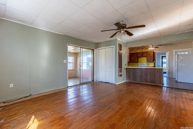a view of an empty room with window and wooden floor