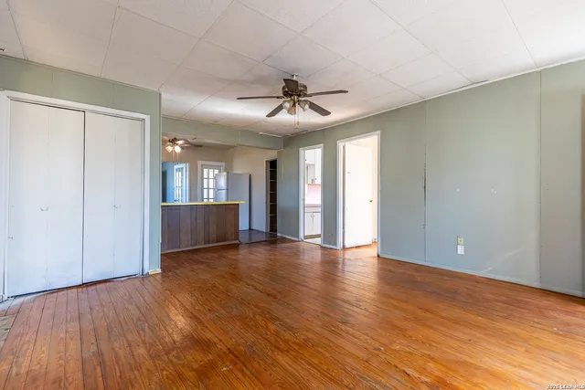 a view of an empty room with window and wooden floor