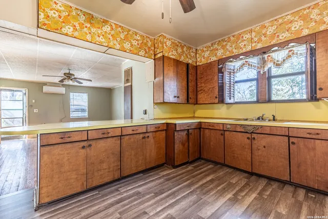 a kitchen with granite countertop sink cabinets and wooden floor
