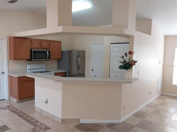 a kitchen with stainless steel appliances granite countertop a refrigerator a stove and a sink