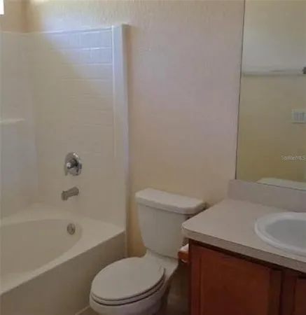 a white toilet sitting next to a bath tub