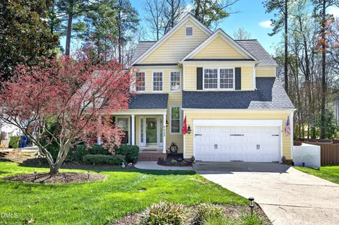 a view of a house with a yard and large tree