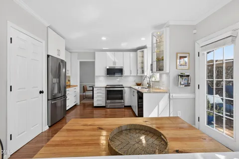 a view of a kitchen with a sink and dishwasher with white walls